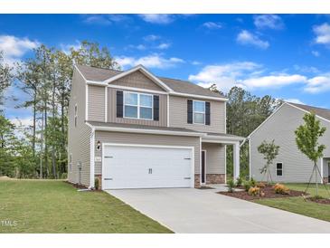 Charming two-story home featuring an attached two-car garage and beautifully landscaped front yard at 111 Rhino Bnd, Oxford, NC 27565