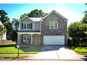 Charming two-story home with a stone accent wall, inviting front porch, and well-maintained lawn at 1122 Birkdale Dr, Mebane, NC 27302