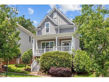 Charming two-story home featuring a cozy front porch and lush, mature landscaping at 220 W Winmore Ave, Chapel Hill, NC 27516