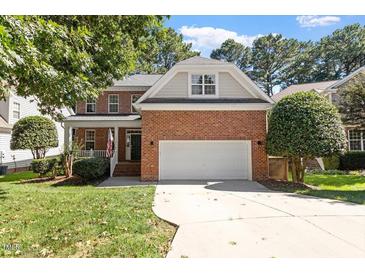 Charming brick home with a well-manicured lawn and attached two car garage at 3921 Robins Nest Ln, Wake Forest, NC 27587
