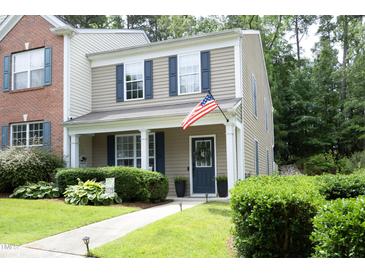 Charming two-story home with blue shutters, an American flag, and landscaped front yard at 4224 Vienna Crest Drive Dr, Raleigh, NC 27613