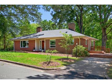 Charming brick home featuring a well-manicured lawn and mature trees, providing a peaceful and inviting curb appeal at 503 Tarleton Ave, Burlington, NC 27215