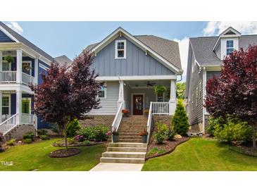 Charming home with brick foundation, landscaped yard, and welcoming staircase leading to the front porch at 690 Great Ridge Pkwy, Chapel Hill, NC 27516