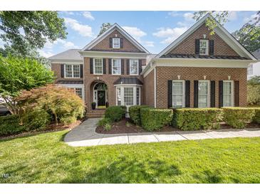 Charming brick home with manicured landscaping, black shutters, and a welcoming front entrance at 9021 Winged Thistle Ct, Raleigh, NC 27617