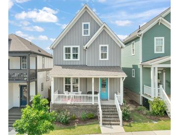 Charming two-story home featuring a welcoming front porch and stylish, gray siding at 1006 Whistler St, Durham, NC 27713