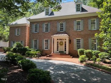 Beautiful brick two-story home featuring manicured landscaping and a welcoming front entrance with wreath at 1105 Tazwell Pl, Raleigh, NC 27612