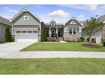 Charming home featuring a well-manicured lawn, a two-car garage and a welcoming front porch at 129 Damsire Way, Cary, NC 27513