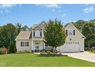 Charming two-story home featuring a well-manicured lawn and attached two-car garage at 142 Scarlet Oak Run, Clayton, NC 27520