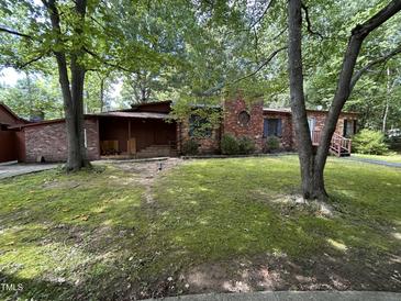 Charming brick home featuring a lovely front yard and covered porch at 194 John Mitchell Rd, Youngsville, NC 27596