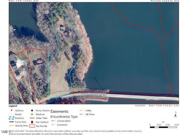 An aerial view shows the property's proximity to the lake and surrounding trees at 2011 Bowmantown Rd, Roxboro, NC 27574