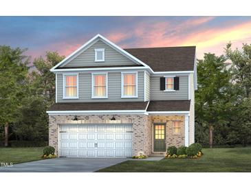 Charming two-story home with a brick facade, two-car garage, and manicured lawn, perfect for Gathering living at 2309 Edenberry Ln, Fuquay Varina, NC 27526