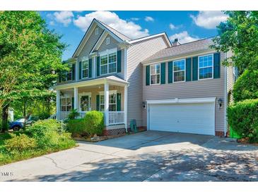 Charming two-story home with attached garage, manicured lawn, and inviting front porch perfect for southern comfort at 3217 Enchanting Way, Raleigh, NC 27616
