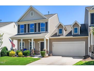 Charming two-story home featuring a welcoming front porch, attached garage, and meticulously landscaped front yard at 437 Excalibur Dr, Morrisville, NC 27560