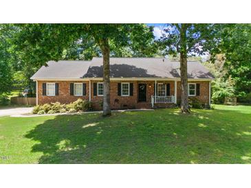 Charming single-story brick home featuring a cozy front porch and well-manicured lawn at 5320 Middleton Rd, Durham, NC 27713