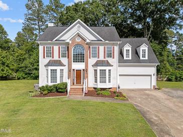 Beautiful two-story home featuring a brick facade, dormer windows, and a well-manicured front lawn at 8 Summertime Ct, Durham, NC 27707