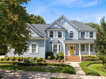 Charming two-story home with a manicured lawn, yellow door, and welcoming front porch at 10513 Cardington Ln, Raleigh, NC 27614