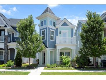 Charming two-story home featuring a unique turret design and colorful accents on a manicured lawn at 1125 Russet Ln, Apex, NC 27523