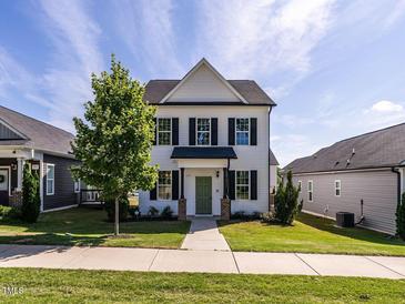 Charming two-story home with white siding, black shutters, and a well-manicured lawn at 157 E Wilson St, Clayton, NC 27520