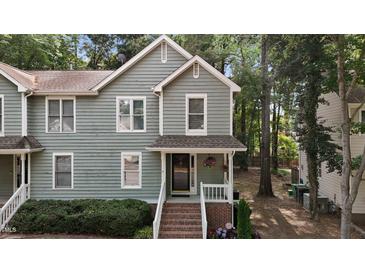 Charming two-story home featuring a covered front porch and tidy landscaping at 1815 Crystal Downs Lane, Raleigh, NC 27604