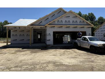 Unfinished home with Typar construction wrap, attached garage, and truck parked in the driveway at 4026 N Nc 581 Hwy, Kenly, NC 27542