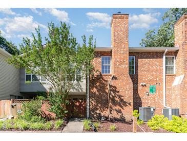 Brick townhome featuring a chimney, exterior storage closet, and sidewalk leading to the front door at 435 Summerwalk Cir # 435, Chapel Hill, NC 27517