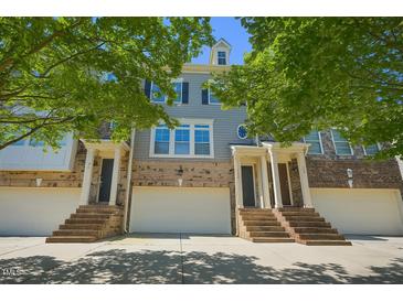 Charming townhome with brick facade, light gray siding, white garage door, and inviting staircase at 453 Panorama Park Pl, Cary, NC 27519