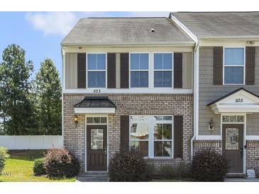 Inviting two-story home with brick facade and well-manicured lawn in a townhome community at 523 Berry Chase Way, Cary, NC 27519