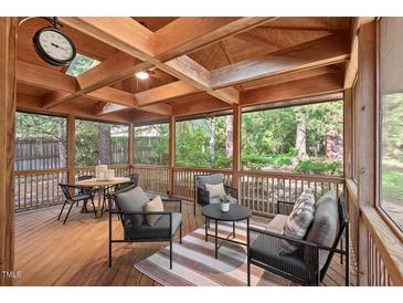 Inviting screened porch with wood flooring, comfortable seating, and views of the landscaped backyard at 5315 Mccormick Rd, Durham, NC 27713