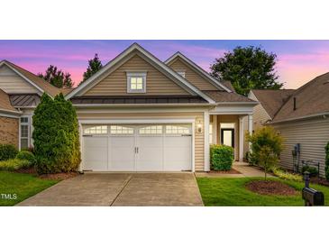 Charming home with a two-car garage, beautiful siding, manicured lawn, and inviting curb appeal at sunset at 575 Tomkins Loop, Cary, NC 27519