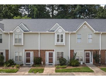 Charming townhome exterior with light gray siding, brick accents, and well-maintained landscaping at 6 Parsons Chase Ln, Durham, NC 27713