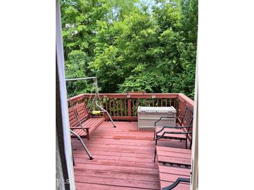View of the deck with a swing and seating, overlooking lush greenery at 651 Berry Chase Way, Cary, NC 27519