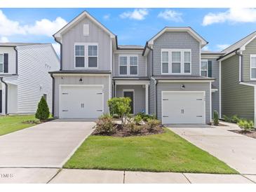 Well-maintained townhomes featuring attached garages, lush lawns, and inviting entrances at 706 Ambrose Hill Lane Ln, Wendell, NC 27591
