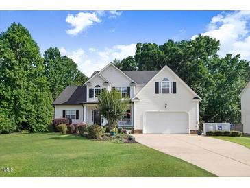 Charming two-story home with a well-manicured lawn, beautiful landscaping, and an attached two-car garage at 74 Fountain Dr, Clayton, NC 27520