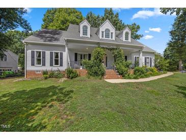 Charming single-Gathering home featuring a welcoming front porch and lush landscaping at 7917 Rooksley Ct, Raleigh, NC 27615