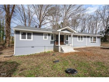 Charming single-story home with gray siding, white trim, and mature trees at 810 Grovemont Rd, Raleigh, NC 27603