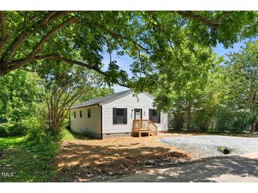 Charming single-story home with white siding, dark shutters, and a welcoming wooden porch at 810 Williams St, Burlington, NC 27217