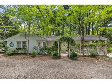 Charming home with an arched, vine-covered entrance and gravel drive at 914 Cindy St, Cary, NC 27511