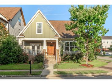 Inviting craftsman-style home with a well-manicured lawn and charming front porch at 997 Windy Rd, Apex, NC 27502