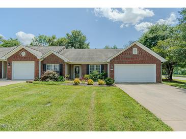 Charming brick and siding home with a well-maintained lawn and attached one car garage at 101 Kingston Ln, Graham, NC 27253