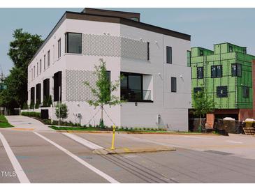 Modern, three-story building with white brick and black-trimmed windows on a sunny day at 1311 Chamblee Hill Ct, Raleigh, NC 27608