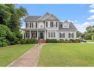 Charming two-story home features a well-manicured lawn, inviting front porch, and classic architectural details at 1505 Mclaurin Ln, Fuquay Varina, NC 27526