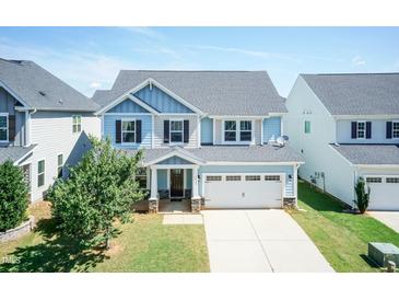 Charming two-story home featuring a manicured lawn and a two-car garage on a sunny day at 2008 Campana Dr, Raleigh, NC 27603