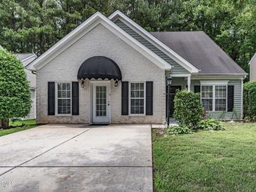 Charming one-story home featuring a well-manicured lawn and a striking black awning over the front door at 2109 Star Sapphire Dr, Raleigh, NC 27610