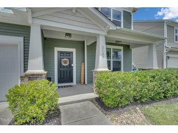 Charming front door with decorative wreath, welcome sign, and stone accents on a two-story home at 2123 Scarlet Sage Dr, Durham, NC 27704