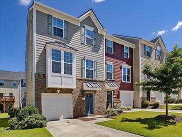 Charming townhome with well-maintained lawn, attached garage, and brick accents at 215 Brier Summit Pl, Durham, NC 27703