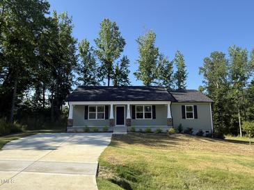 Charming single-story home featuring a welcoming front porch and well-manicured lawn at 299 Starry Sky Dr, Benson, NC 27504