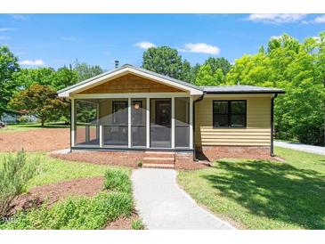 Charming bungalow with a screened-in porch, yellow siding, and landscaped front yard at 3213 Mid Pines Rd, Raleigh, NC 27606