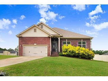 Lovely one-story red brick house with a manicured lawn and a two-car garage at 88 Longo Ln, Benson, NC 27504