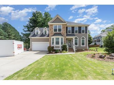 Charming two-story home with stone accents, manicured lawn, and attached two car garage at 101 Lochmere Forest Dr, Cary, NC 27518