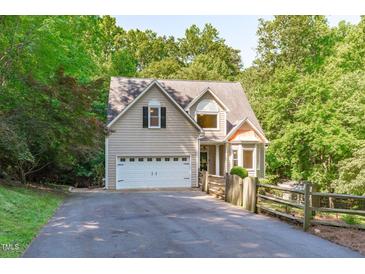 Charming home with a two-car garage, manicured landscaping, and an inviting driveway surrounded by mature trees at 105 Greenbriar Ct, Chapel Hill, NC 27516
